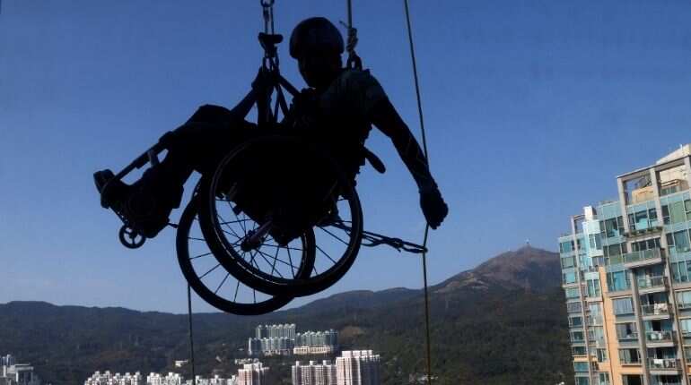 Lai Chi-wai, a paraplegic climber, attempts to climb the 320-metre tall Nina Tower using only his upper body strength, in Hong Kong, China January 16, 2021. On this attempt, Lai completed 250-meters (75/f), as he faced strong winds. Picture taken January 16, 2021