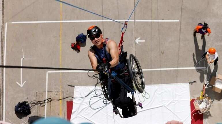 Lai Chi-wai, a paraplegic climber, attempts to climb the 320-metre tall Nina Tower using only his upper body strength, in Hong Kong, China January 16, 2021. On this attempt, Lai completed 250-meters (75/f), as he faced strong winds. Picture taken January 16, 2021