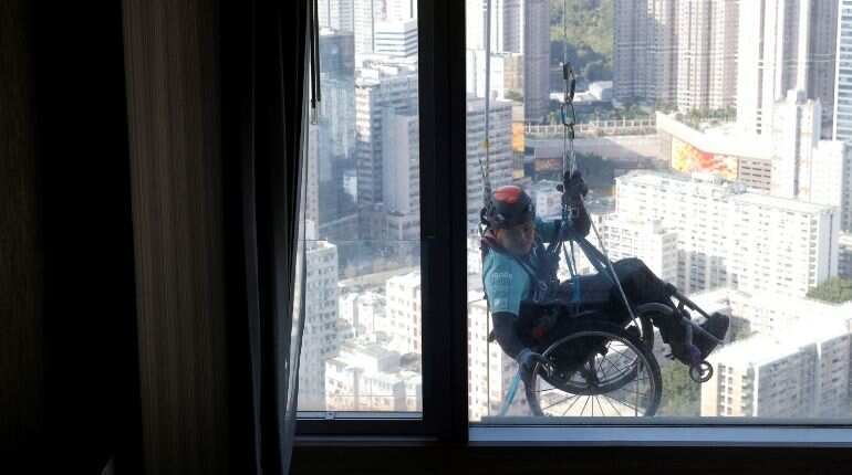 Lai Chi-wai, a paraplegic climber, attempts to climb the 320-metre tall Nina Tower using only his upper body strength, in Hong Kong, China January 16, 2021. On this attempt, Lai completed 250-meters (75/f), as he faced strong winds. Picture taken January 16, 2021
