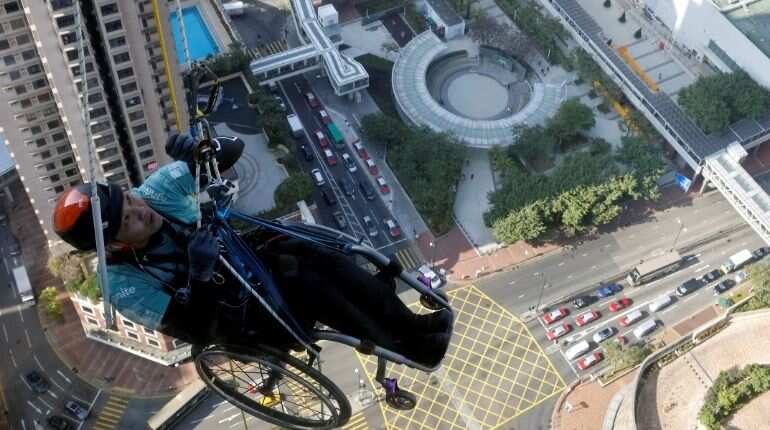 Lai Chi-wai, a paraplegic climber, attempts to climb the 320-metre tall Nina Tower using only his upper body strength, in Hong Kong, China January 16, 2021. On this attempt, Lai completed 250-meters (75/f), as he faced strong winds. Picture taken January 16, 2021