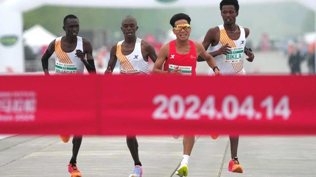 Chinese runner He Jie, Ethiopian Dejene Hailu Bikila and Kenyans Robert Keter and Willy Mnangat at the finish line of the Beijing Half Marathon on April 14, 2024 | Reuters
