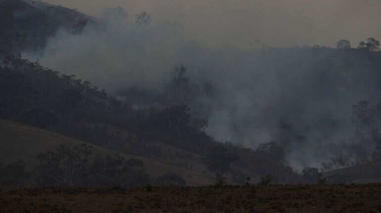 Firefighters spray water on smouldering patches left in the wake of a bushfire near Bumbalong, New South Wales, Australia, February 2, 2020.