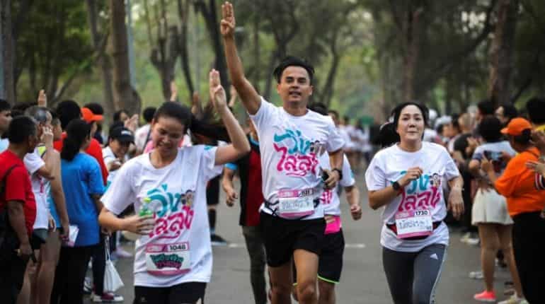 Runners flash three finger salute as they attend a "Run Against Dictatorship" event
