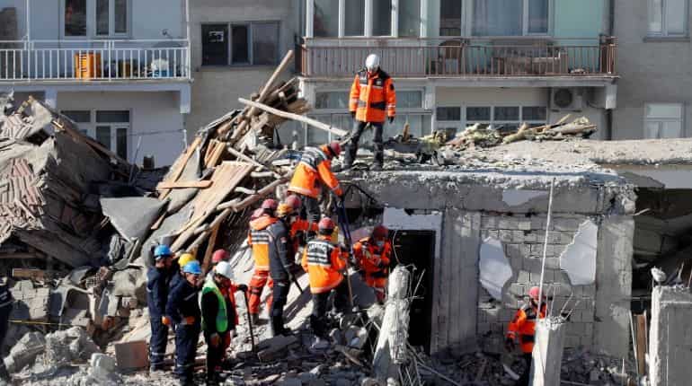 Rescue workers search the site of a collapsed building