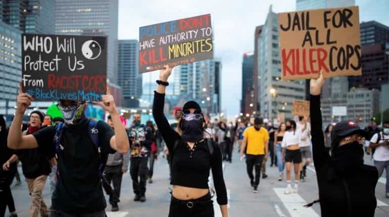 Protesters wearing protective face coverings peacefully march down Broadway from the State Capitol despite the 9 p.m. curfew in Denver, Colorado, U.S., June 1, 2020