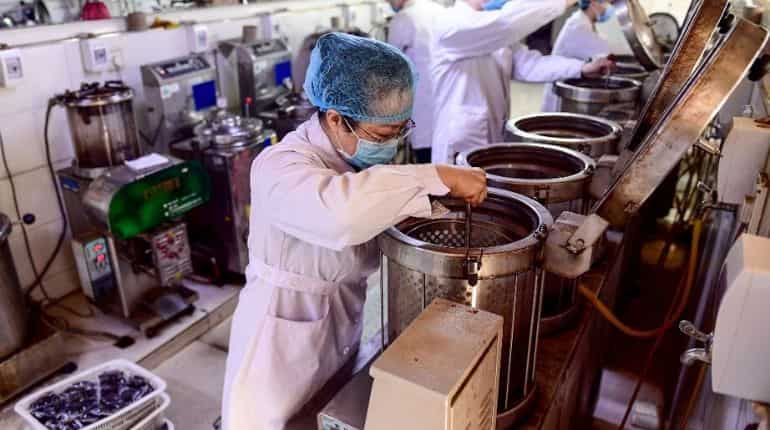his photo taken on February 20, 2020 shows a medical worker boiling traditional Chinese medicine at a hospital in Shenyang in China