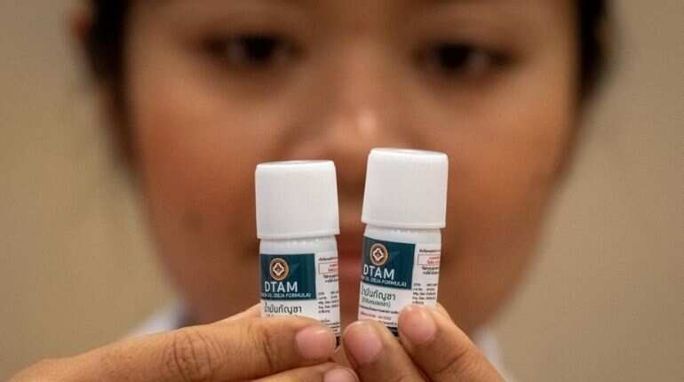 A nurse looks at vials with cannabidiol (CBD) oil during the opening of a cannabis (marijuana) clinic at the Department of Development of Thai Traditional and Alternative Medicine in Bangkok on January 6, 2020