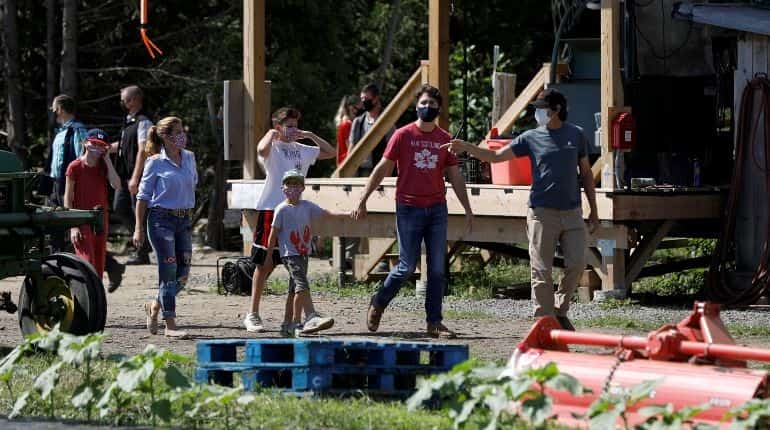 Canada's Prime Minister Justin Trudeau and his family, with farm manager Jason Gray, arrive at an Ottawa Food Bank farm on Canada Day