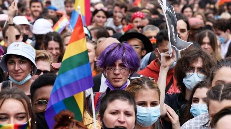 A participant holds a rainbow flag as people take part at the annual Pride March parade in Paris on June 26, 2021.