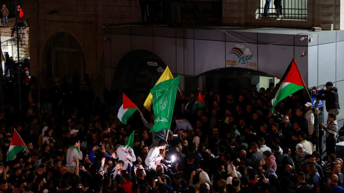 People watch from a window as released Palestinian prisoners leave the Israeli military prison, Ofer, after hostages-prisoners swap deal between Hamas and Israel near Ramallah in the Israeli-occupied West Bank November 24, 2023