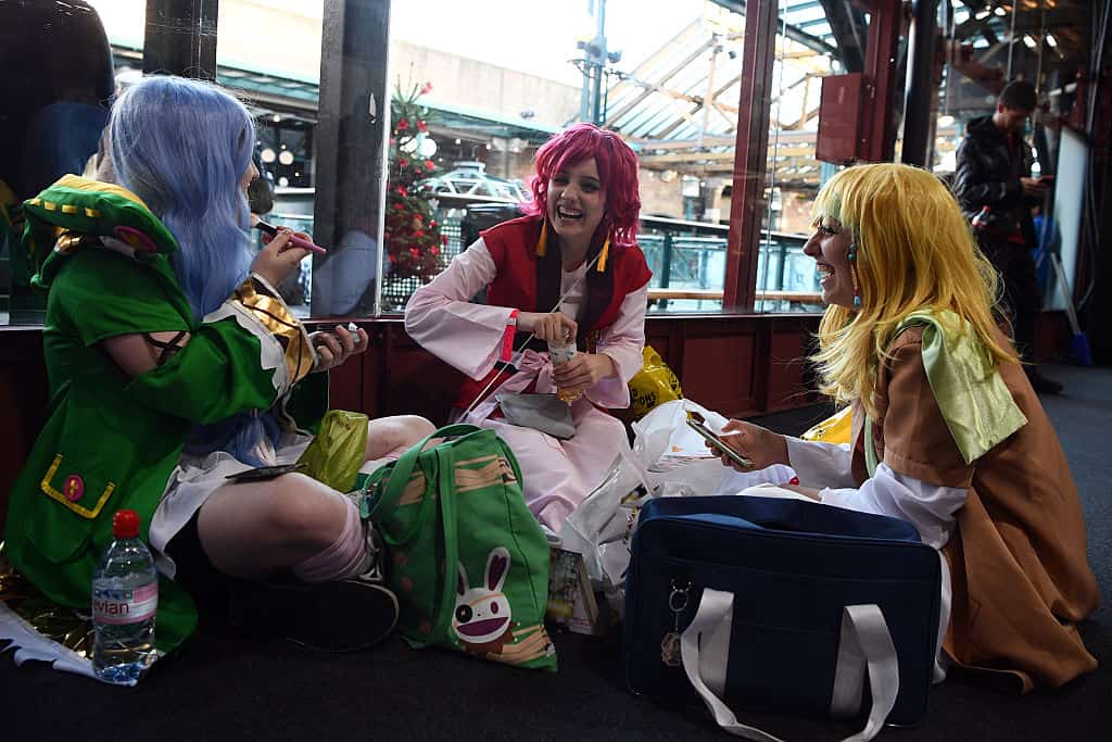 Women in cosplay outfits share a joke as they visit the Hyper Japan Christmas Market in London, England
