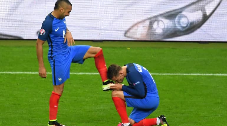 France's forward Dimitri Payet's shoes is kissed by France's forward Antoine Griezmann.