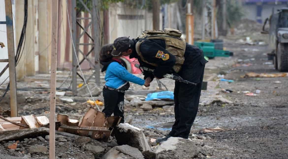 A member of Iraqi special forces kisses a child in the neighbourhood of al-Barid east of Mosul