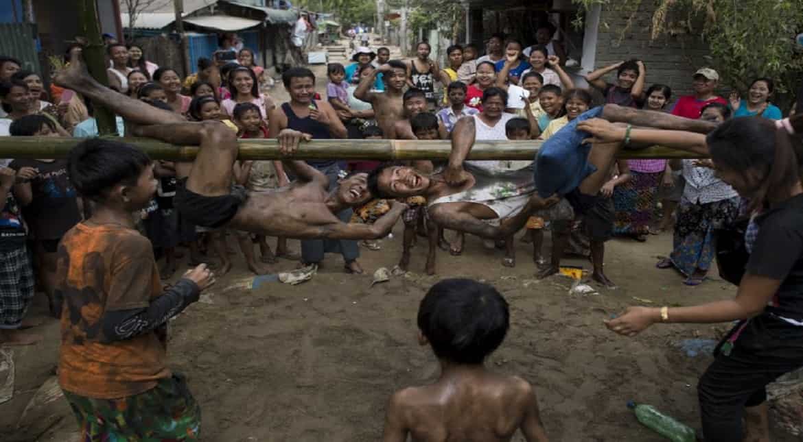 Youths play a traditional pillow fight game on a bamboo pole during festivities marking the 69th anniversary of Myanmar