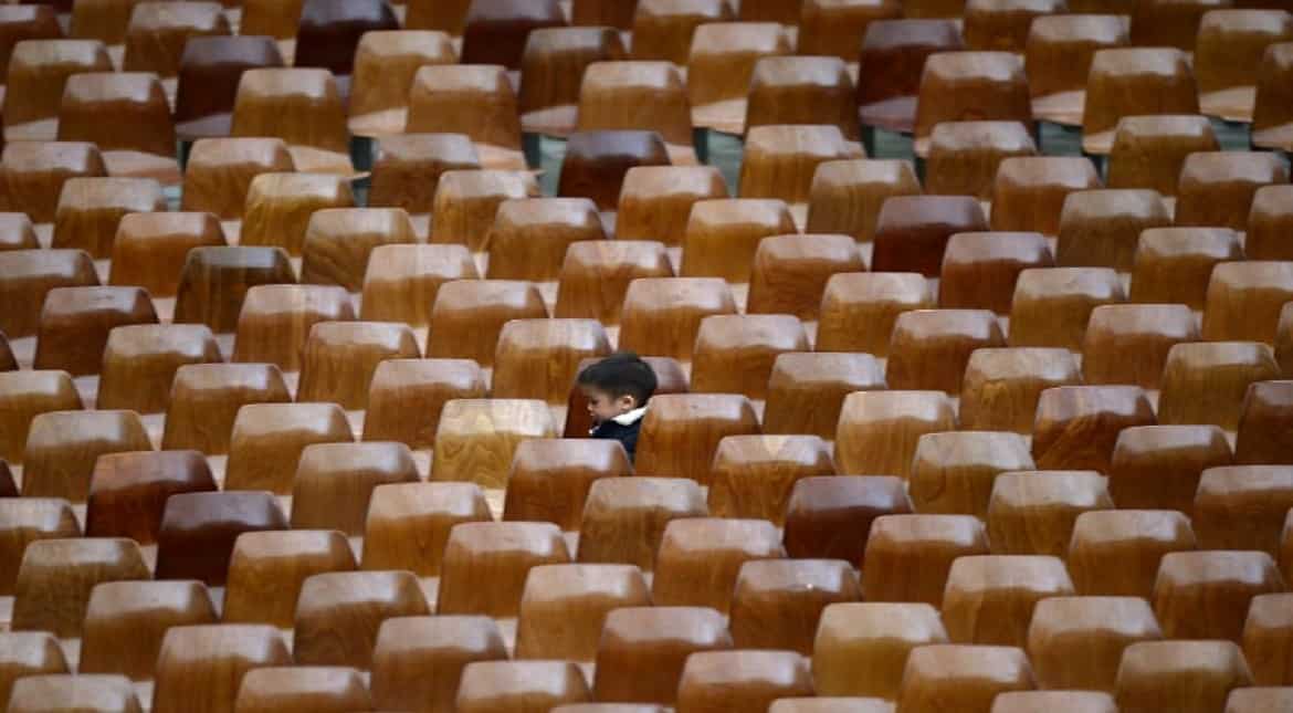 A child plays between chairs of the Paul VI audience Hall at the end of Pope Francis' weekly general audience in Vatican.
