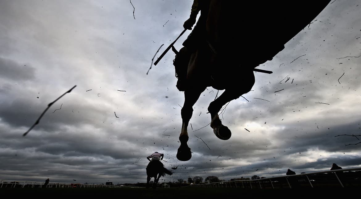 Horses jump a fence during the Stella Artois Supporting Bangor Handicap Steeple Chase at Bangor-On-Dee Racecourse in Bangor, Wales.