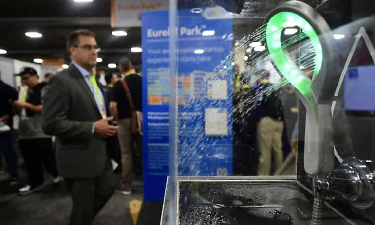 A man walks past the Hydrao Loop shower head from SmartandBlue.