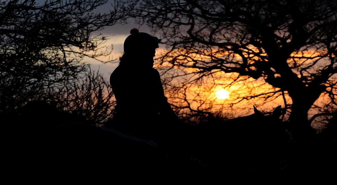 A Jockey makes their way along the gallops at sunrise at Gib Hill Stables in Bridgwater, England.