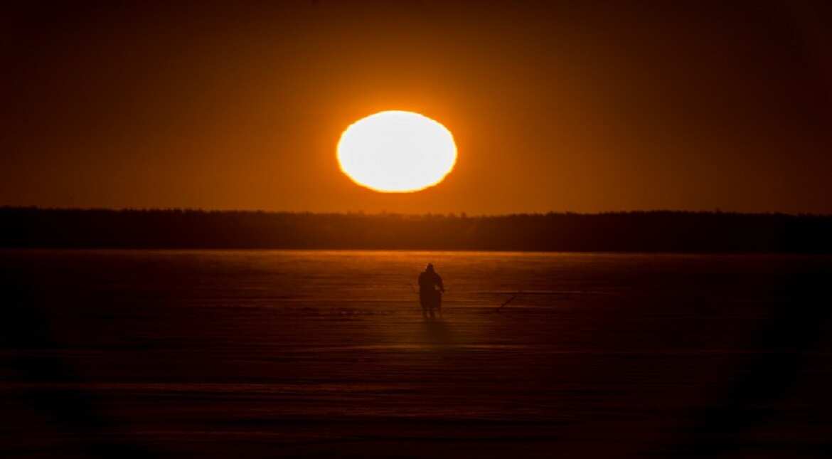 A man is on his way for ice-fishing at sunrise on the frozen sea in Vaasa by -15?C.