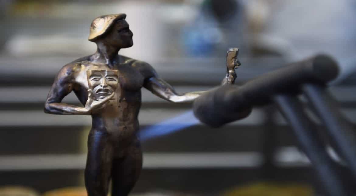 A worker uses a torch to heat up the bronze of the Screen Actors Guild's "The Actor" statuette