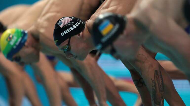 US Caeleb Remel Dressel (C) competes in a men's 50m butterfly final