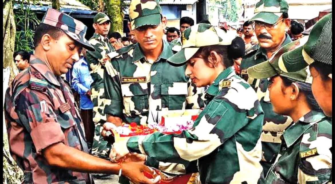 Indian woman constable tying rakhi to a Bangladeshi soldier