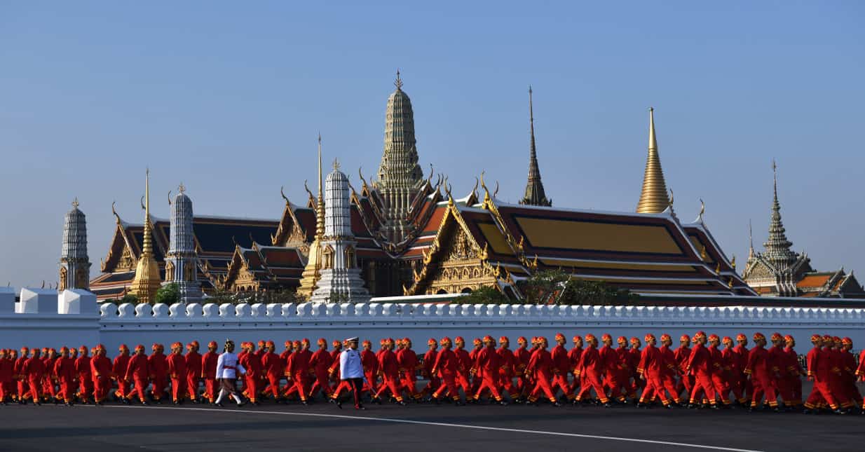 Performers walk from the Grand Palace