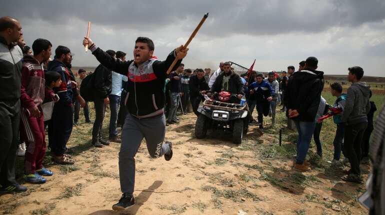 Clashes as thousands of Gazans march near Israel border Clashes as thousands of Gazans march near Israel border