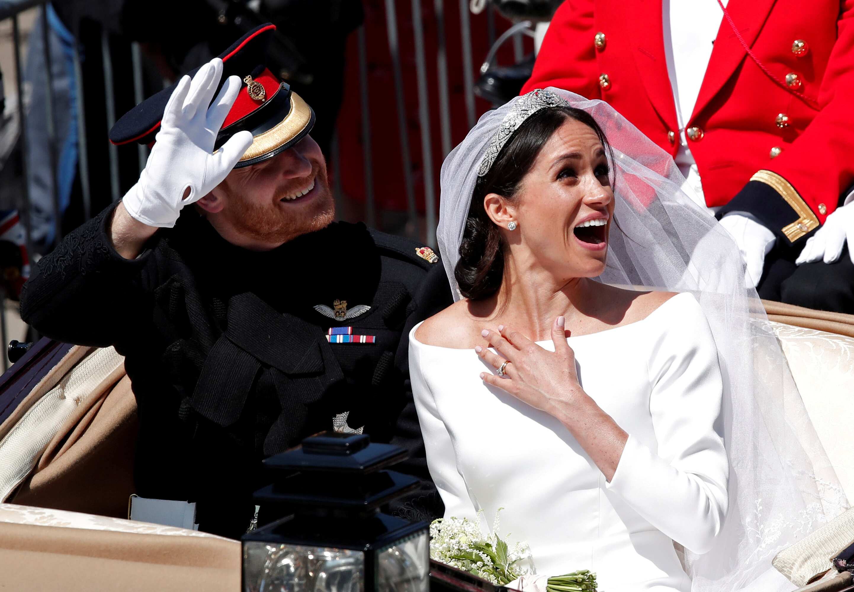 Prince Harry and his wife Meghan ride a horse-drawn carriage