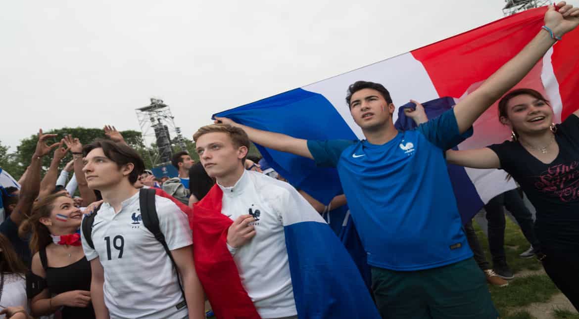 Football fans wave a French national flag in the Eiffel Tower fan zone as the French capital prepares to host the 2016 UEFA European Football Championship, June 10, 2016 in Paris, France. (Photo by T