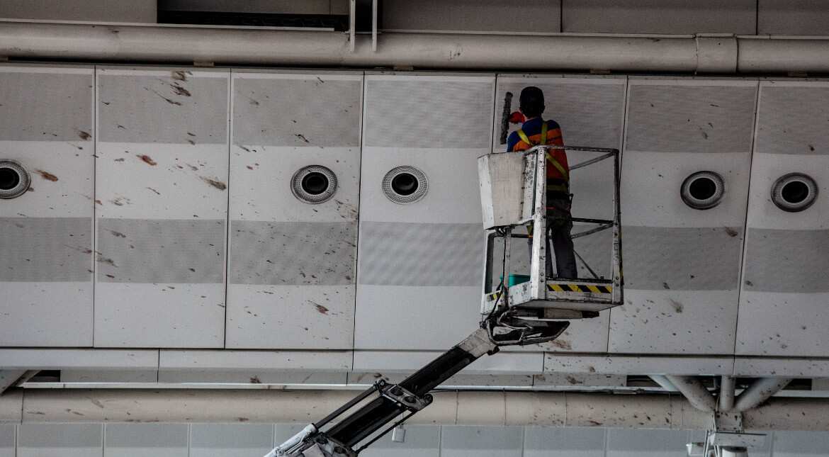 A worker cleans blood from the roof of Istanbul Ataturk airport. Three attackers with possible links to the IS entered the airport Tuesday night with firearms and explosives and opened fire.?