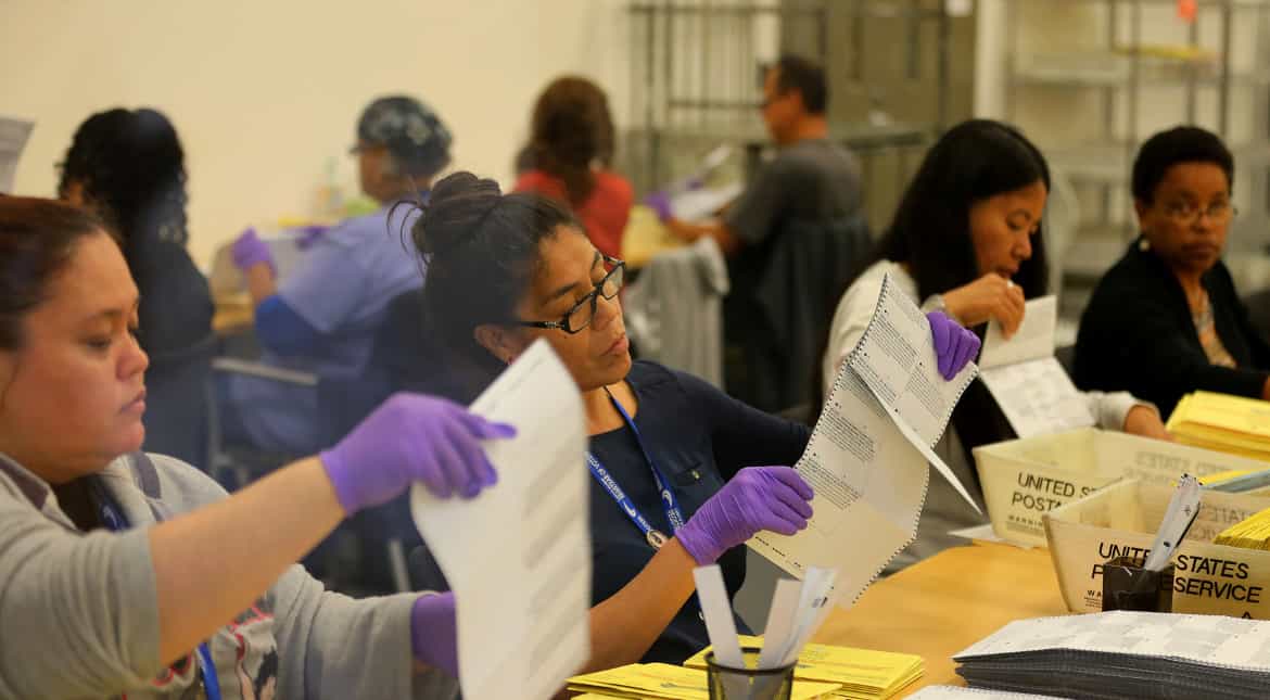 Election workers verify mail-in ballots in San Diego.