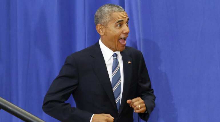 US President Barack Obama reacts as he arrives to deliver remarks on education at Benjamin Banneker Academic High School in Washington,DC.