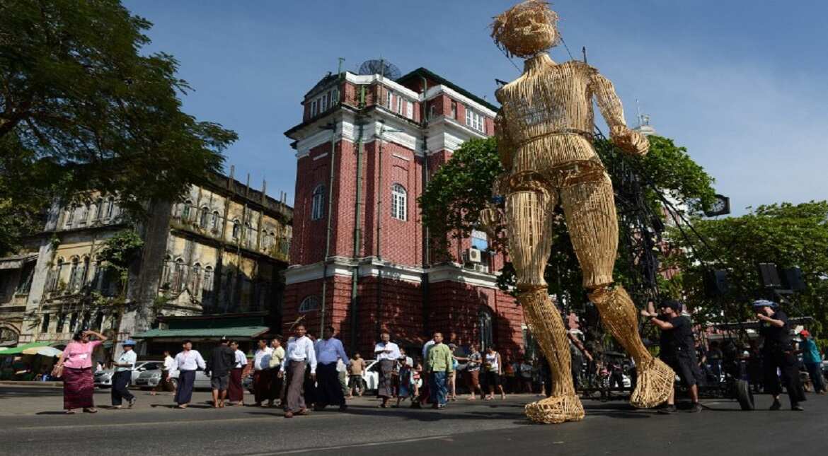 Residents look at an eight-metre-tall wicker puppet from the French cultural group L?Homme Debout