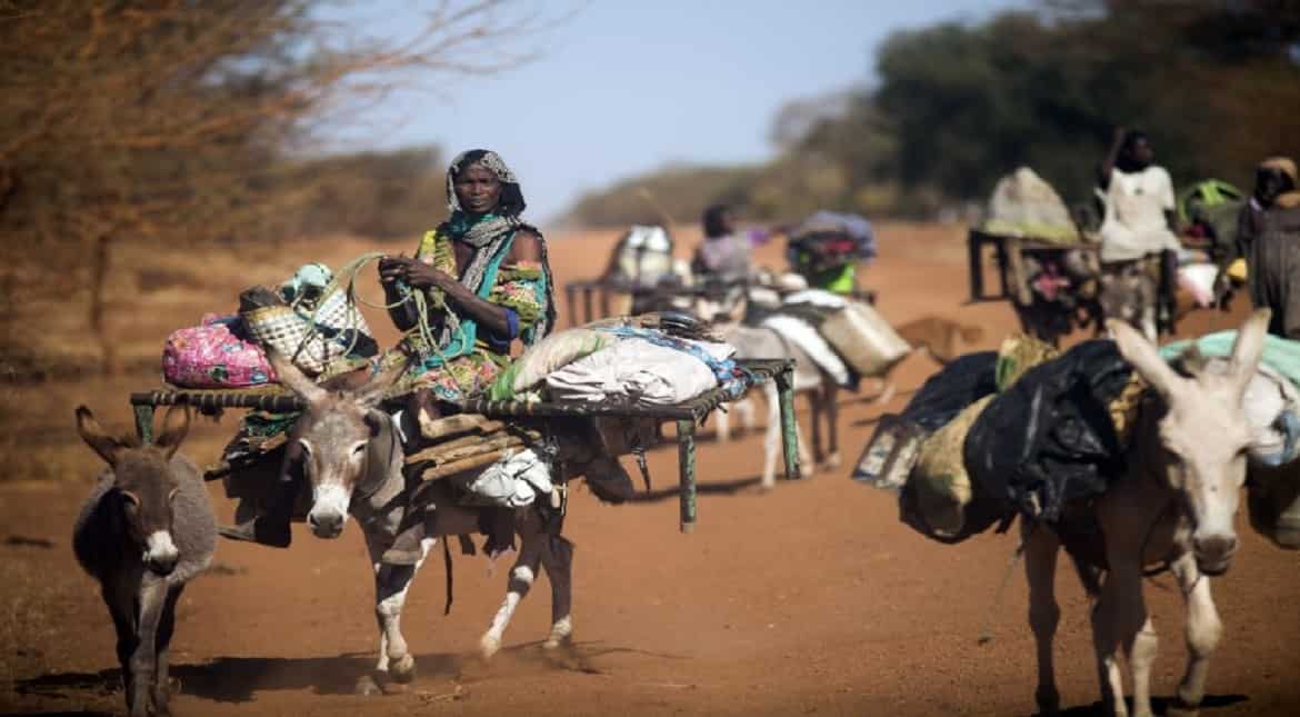 A woman rides a donkey as nomad families from the Misseryia area