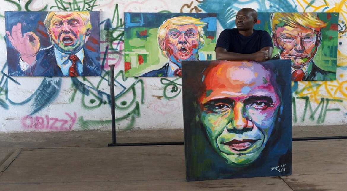 Kenyan artist Evans Yegon aka "Yogonizer" poses with his paintings of USA President Barack Obama