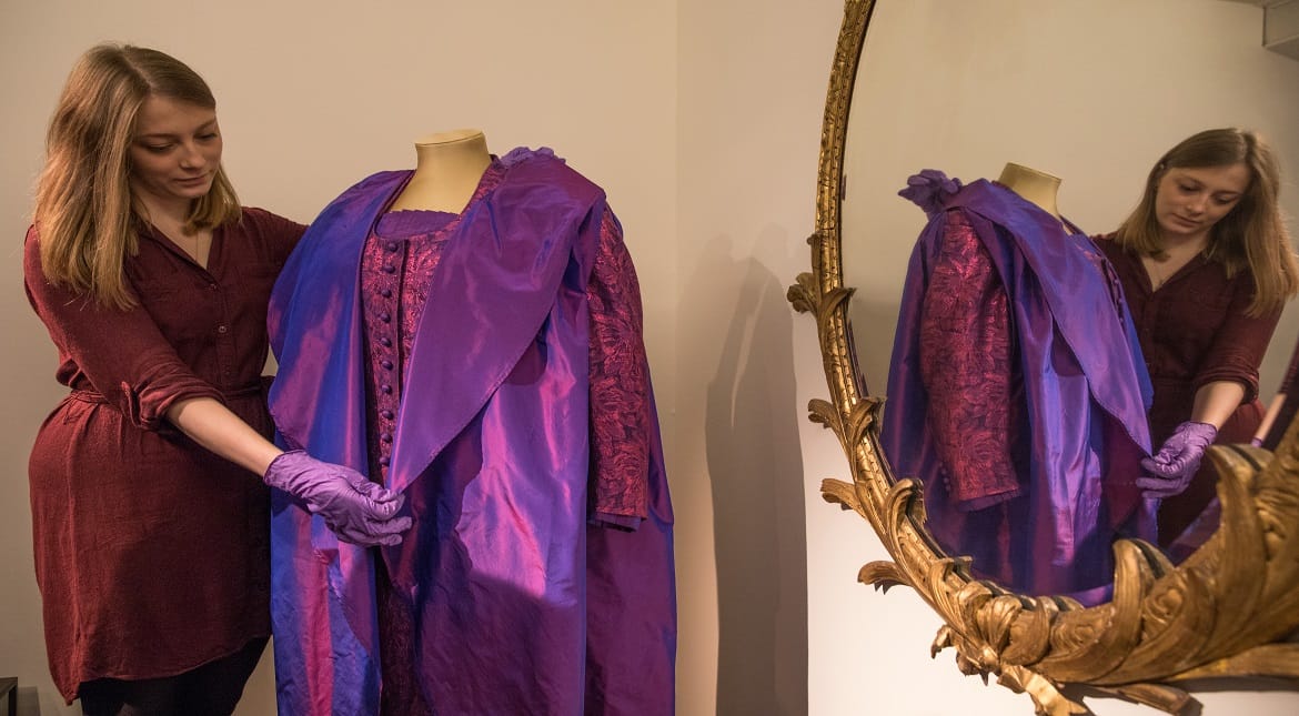 A V&A employee poses next to an 'Evening Ensemble' at the Victoria and Albert Museum in London, England.