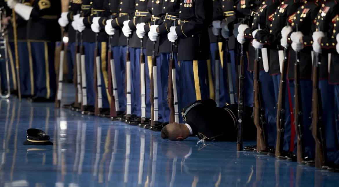 A member of the US Army Honor Guard lays on the floor after passing out during an Armed Forces Full Honor Farewell Review for US
