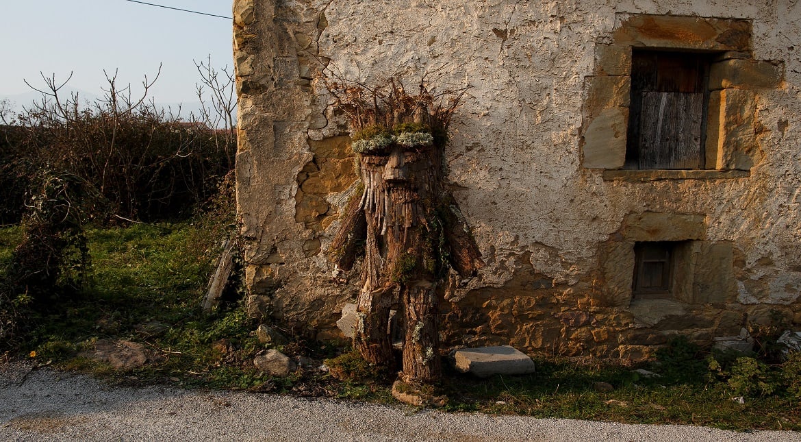 A man dressed as a tree take rest against a wall during the Vijanera festival  in Silio, Cantabria province, Spain.