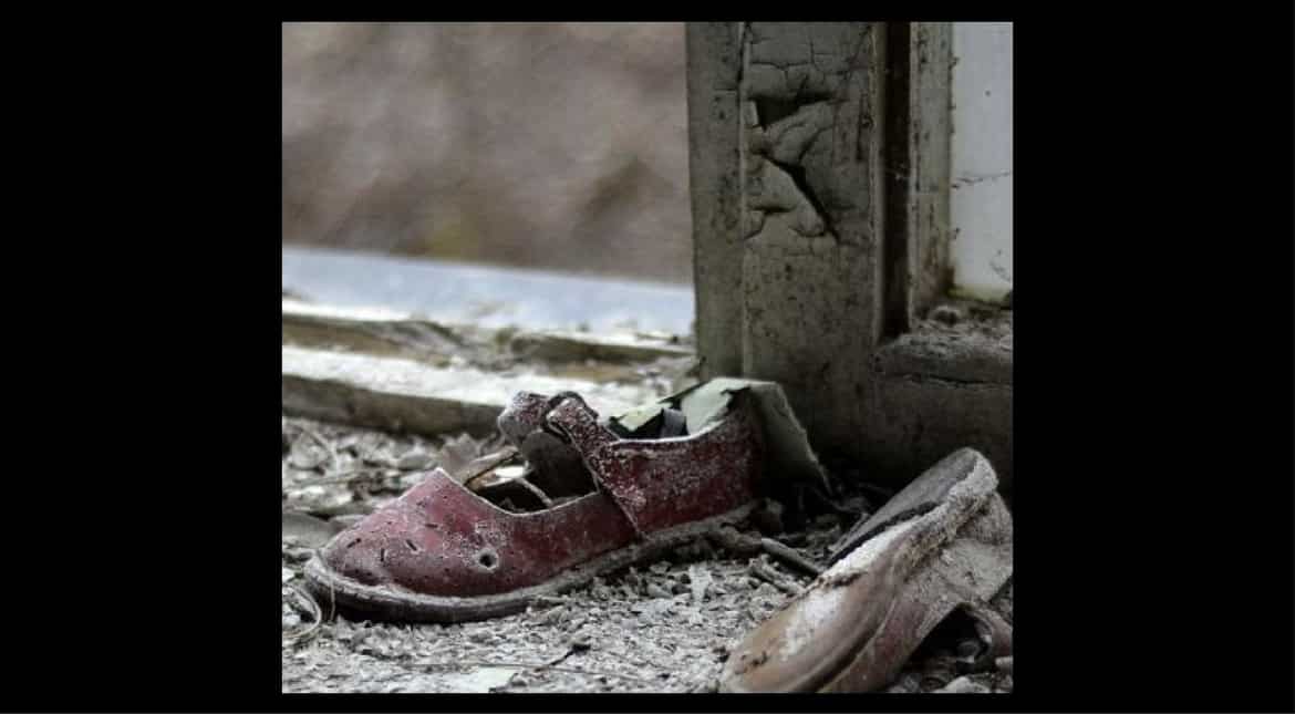A child's shoes sit amongst a pile of rubble in the deserted town of Pripyat