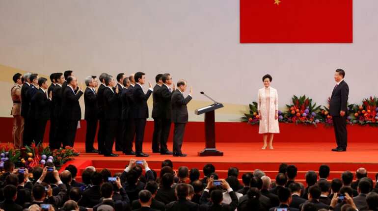 China's Xi warns Hong Kong to toe the line, swears in new leader