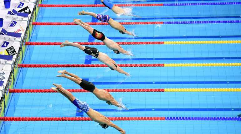Swimmers compete in the men's 100m breaststroke final