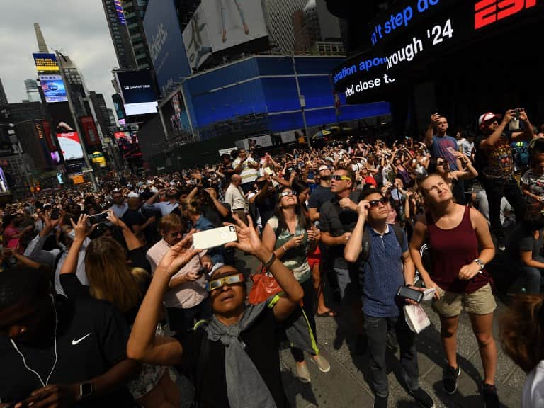 People view the partial solar eclipse from Times Square in New York.