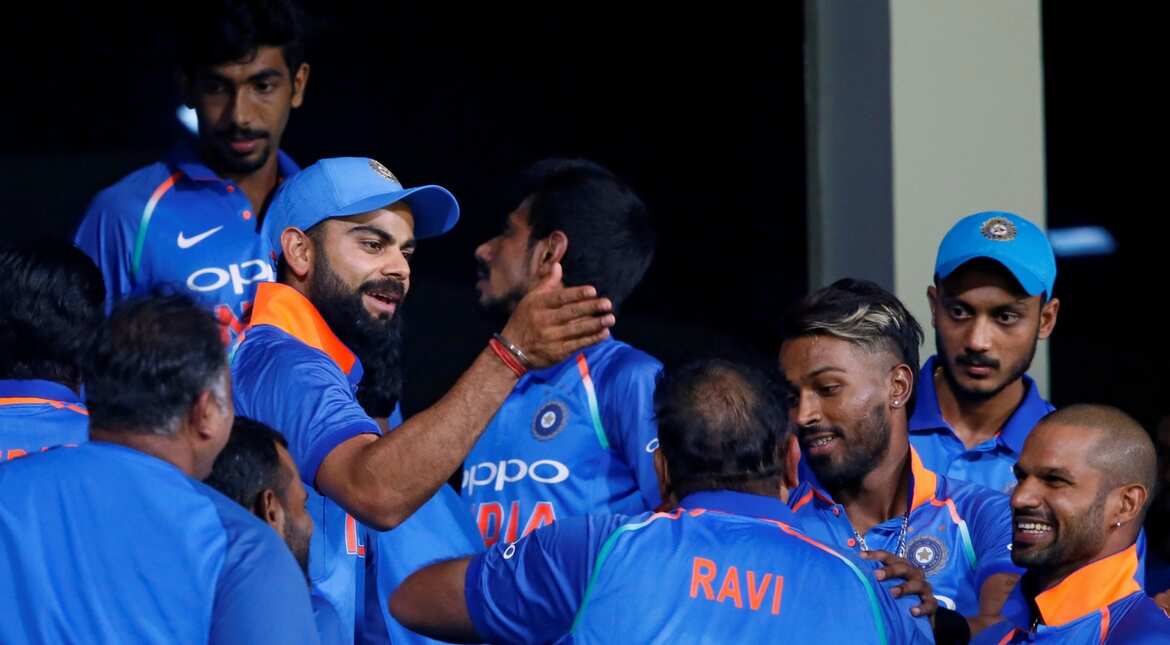India's captain Virat Kohli celebrates with his teammates at the dressing room after they won the match