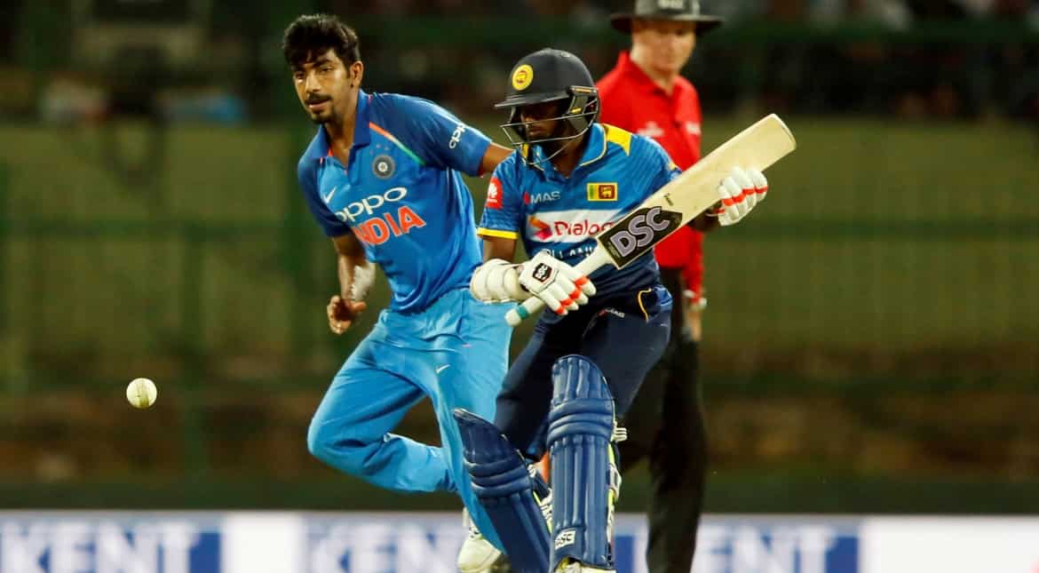 India's Jasprit Bumrah runs to the ball next to Sri Lanka's Akila Dananjaya