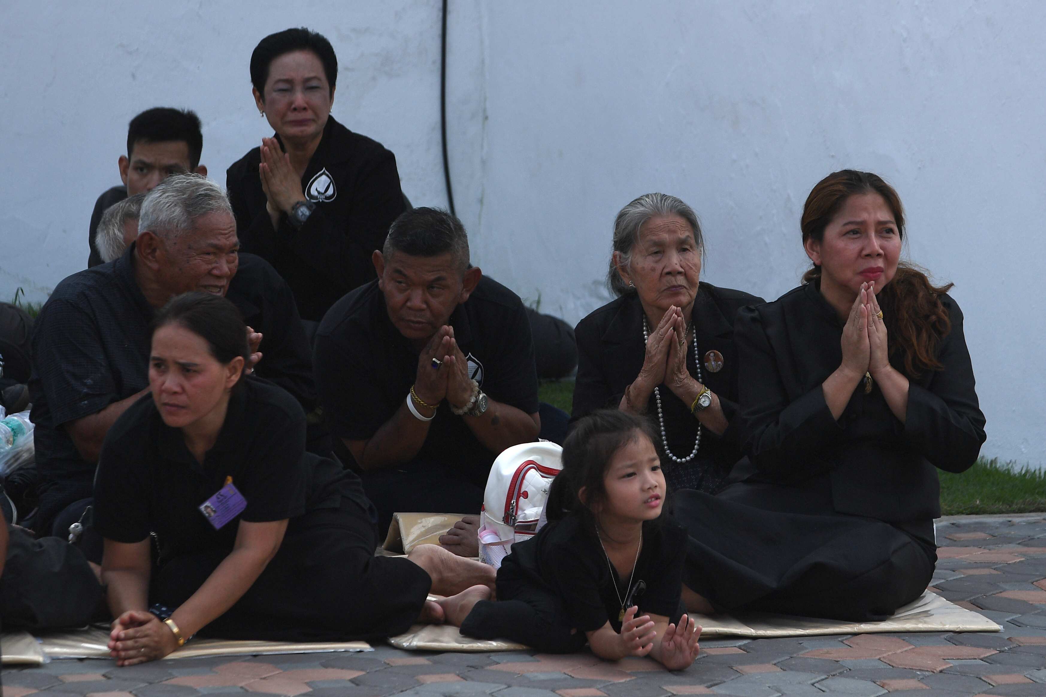 Mourners clasp their hands as the Royal Urn passes