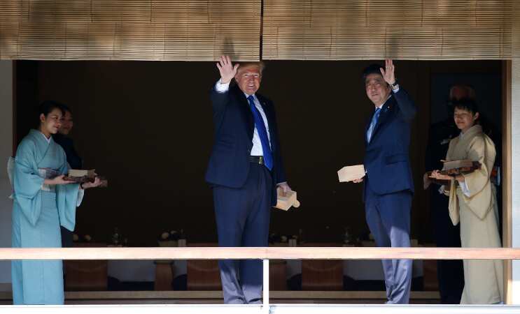 Trump throws entire fish food box into koi carp pond in Japan
