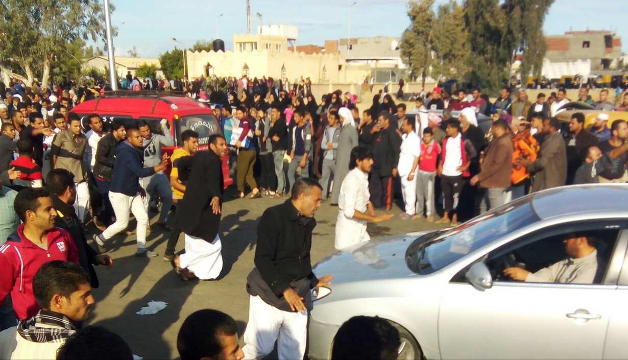 Egyptians gather at the site of a gun and bombing attack
