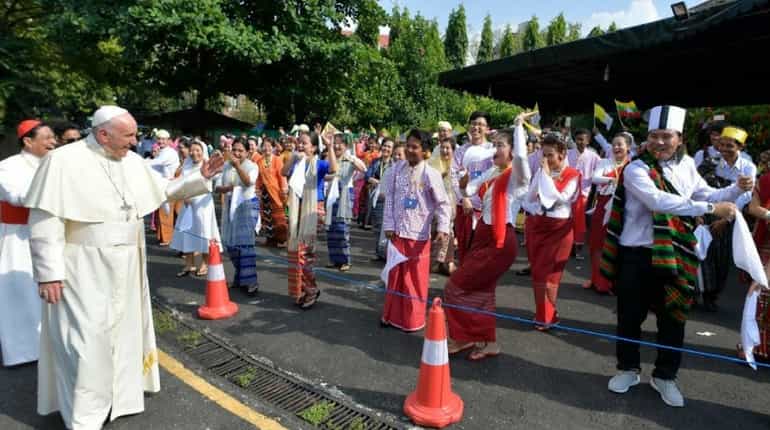 Pope Francis greets the crowd as he arrives at  Yangon