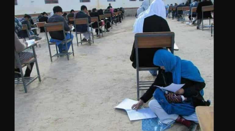 Heartwarming picture shows Afghan woman nursing her baby while writing exam Heartwarming picture shows Afghan woman nursing her baby while writing exam